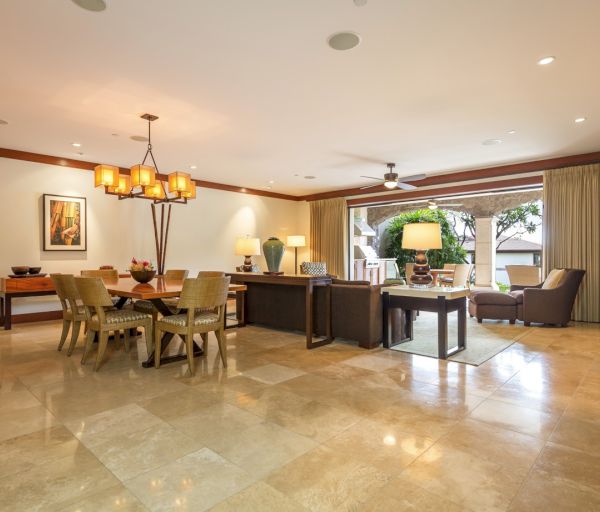 The image shows a spacious, stylish living and dining area with modern furniture, a luxurious ambiance, and natural light.