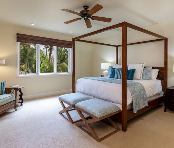 The image shows a cozy bedroom with a four-poster bed, soft lighting, and a serene atmosphere, perfect for relaxation.