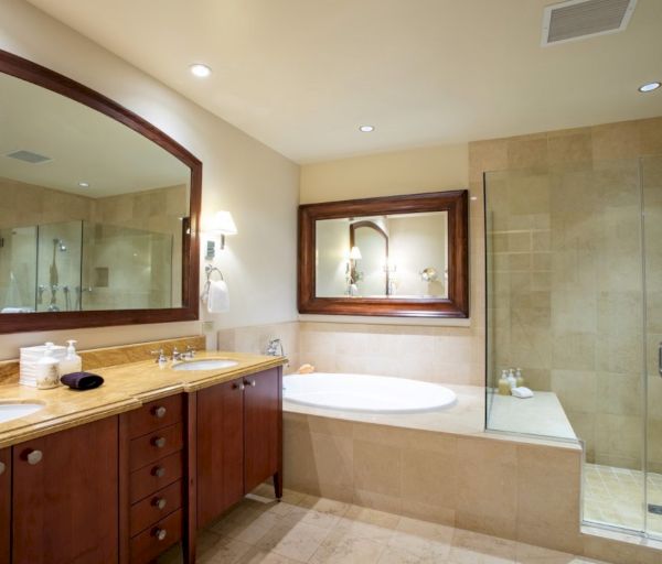 The image features a modern bathroom with a glass shower, a bathtub, and elegant wooden cabinetry and mirrors.